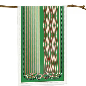 Detail of emerald green silk scarf with stripes and geometric chain patterns on a branch