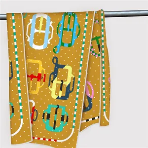 Detail of a ginger yellow scarf featuring retro buckle prints and white polka dots
