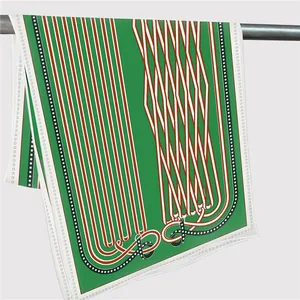 Detail of emerald green silk scarf with geometric chain patterns and rolled edges