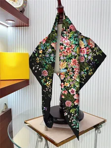 Detailed close-up of 90cm silk scarf with vibrant floral patterns on black fabric