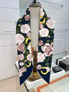 Dettaglio dello scialle twilly blu navy con fiori di camelia rosa su un manichino bianco