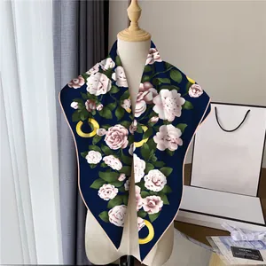 Dettaglio di un foulard in seta con fiori di camelia rosa su fondo blu navy elegante