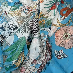 Detail of blue georgette scarf showing artistic floral, zebra and insect patterns