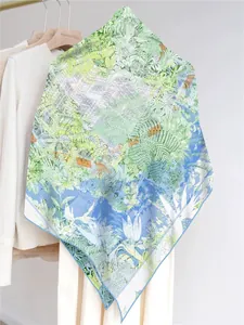 Detail of a lightweight georgette shawl featuring tropical green palm leaves and blue gradient