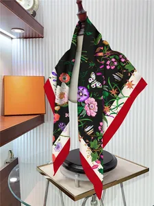 Detail of floral silk scarf showing vibrant tulip patterns and luxury contrasting borders