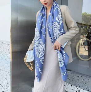 Detail van elegante lila blauwe sjaal met vintage patronen en een beige blazer