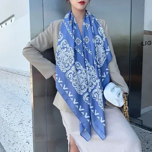 Detail van blauw-witte barokke sjaal met bloemmotieven gedragen over de schouder