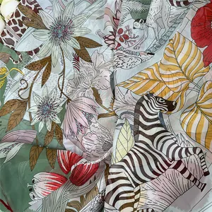 Close-up of lightweight georgette scarf featuring tropical flora and giraffe print