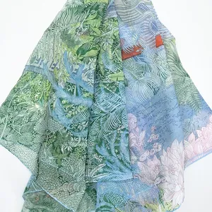 Macro detail of sheer georgette shawl featuring tropical green leaves and pink lotus