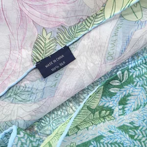 Detail shot of 100% silk floral scarf showing soft texture and premium quality label