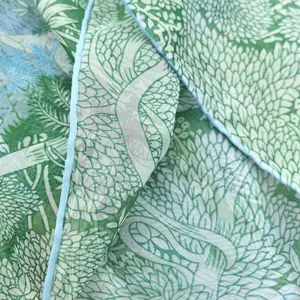 Close-up of green leaf pattern on georgette scarf with light blue rolled edge detail