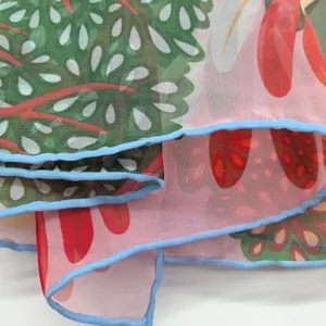 Detailed macro view of thin georgette scarf fabric with leaf print and fine blue edges