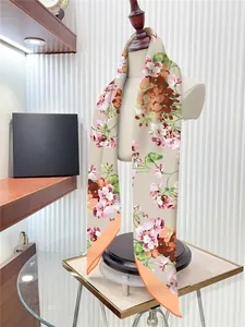 Detailed drape of 90cm floral twill silk scarf with vibrant orange block pattern