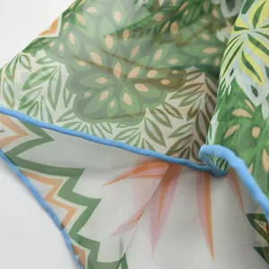 Detailed close-up of georgette shawl with tropical jungle leaves and blue hem stitch