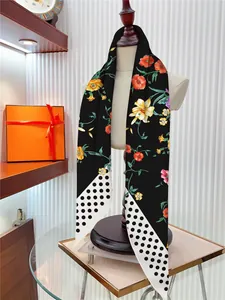Détail du drapé d'un foulard en soie noire à fleurs avec motif à pois sur un mannequin
