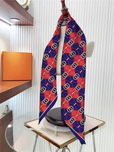 Detail view of the elegant red and blue chain pattern silk scarf on a beige mannequin