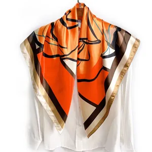 90cm silk-like square scarf featuring orange geometric floral patterns on a hanger