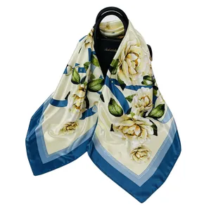 Sciarpa di seta quadrata con rose gialle e bordi blu su una borsa di pelle nera