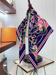 Détails des motifs floraux et de chaînes équestres sur un foulard en soie premium