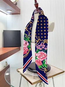 Détail d'un foulard en soie bleu marine avec roses roses, chaînes d'or et étoiles