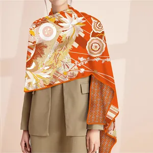 Detail of elegant orange silk shawl with floral pattern and golden wheat ear design