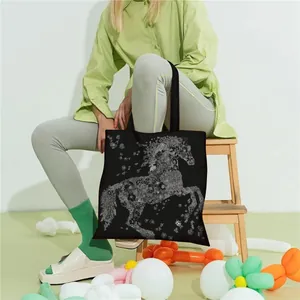 Close-up of black canvas tote bag featuring an artistic white floral horse print design