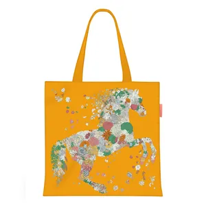 Close-up of bright yellow canvas tote bag featuring an artistic floral horse illustration