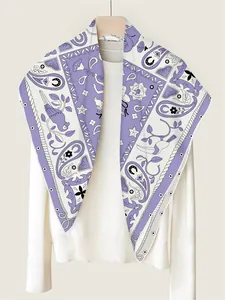 Detail of silk twill scarf with paisley and bird patterns on a white knit sweater