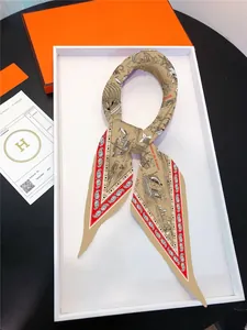 Detailed close-up of a silk scarf with mermaid and ship patterns on a white display tray