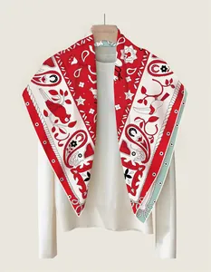 Detail of a 90cm silk scarf with paisley and bird prints over a white knit top