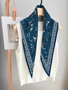Detail of nautical sailboat print silk scarf styled on white sleeveless knitwear