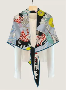 Close-up of silk-textured triangle scarf with giraffe print and tropical floral patterns
