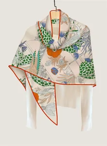 Detailed view of luxury floral and giraffe print scarf with fine orange rolled edges