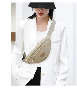 Beige oxford crossbody waist bag shown on model with white blazer and black bucket hat