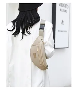 Detail of adjustable wide shoulder strap and black quick-release buckle on beige waist bag