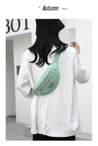 Light green oxford cloth waist bag worn over a white blazer showing water-resistant fabric