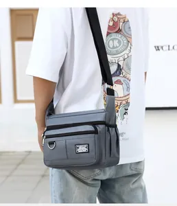 Detail of grey water-resistant oxford crossbody bag with multiple pockets for daily commute