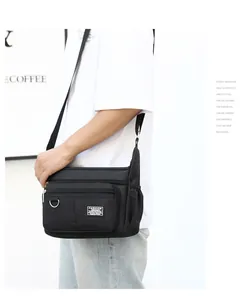 Side view of multi-pocket black oxford cross-body bag worn by model in a casual setting