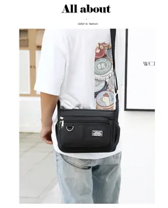 Front detail of black waterproof messenger bag with multiple zipper pockets and metal D-ring