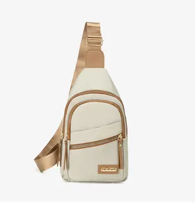Detail view of cream crossbody bag featuring brown trim and golden metal logo plate