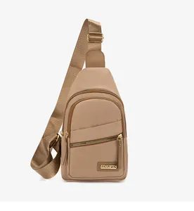 Detail of khaki nylon chest bag showing multi-zip layers and gold metal buckle