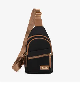 Detail view of the black crossbody chest bag with leather trim and gold metal logo