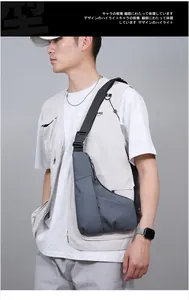 Close-up of grey waterproof crossbody bag with adjustable strap worn on model chest