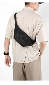 Side view of man wearing a black multi-compartment nylon crossbody bag with adjustable strap