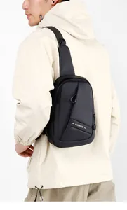 Close-up of black waterproof chest bag with white FASHION lettering and front zipper detail