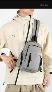 Close-up of gray nylon crossbody bag with multiple zippers and adjustable black strap