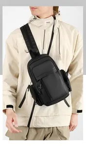 Detailed view of the multi-compartment black nylon tactical chest bag with zippers