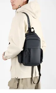 Detail view of water-resistant gray crossbody bag featuring multiple zipper compartments