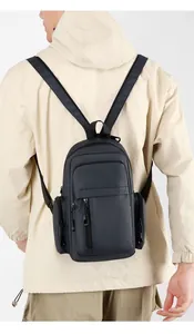 Detail view of a compact navy blue multi-functional sling bag worn on a beige jacket