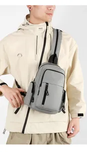 Detail view of a gray waterproof crossbody chest bag showing functional zippers and pockets